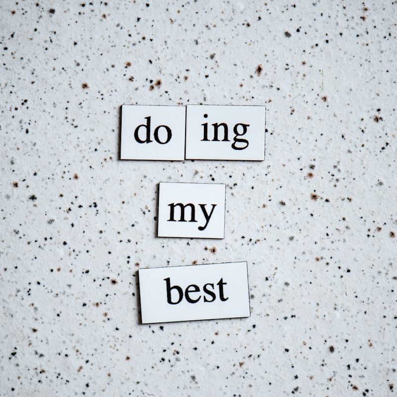 Black and white inspirational quote 'doing my best' on a speckled surface.