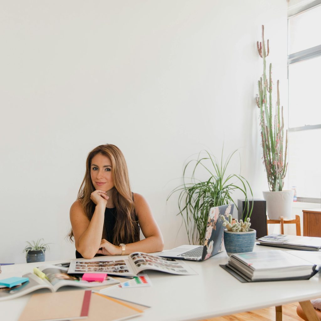 Portrait of a confident businesswoman at her desk surrounded by office supplies and plants.